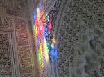 The sun shining on the wall through the stained-glass window